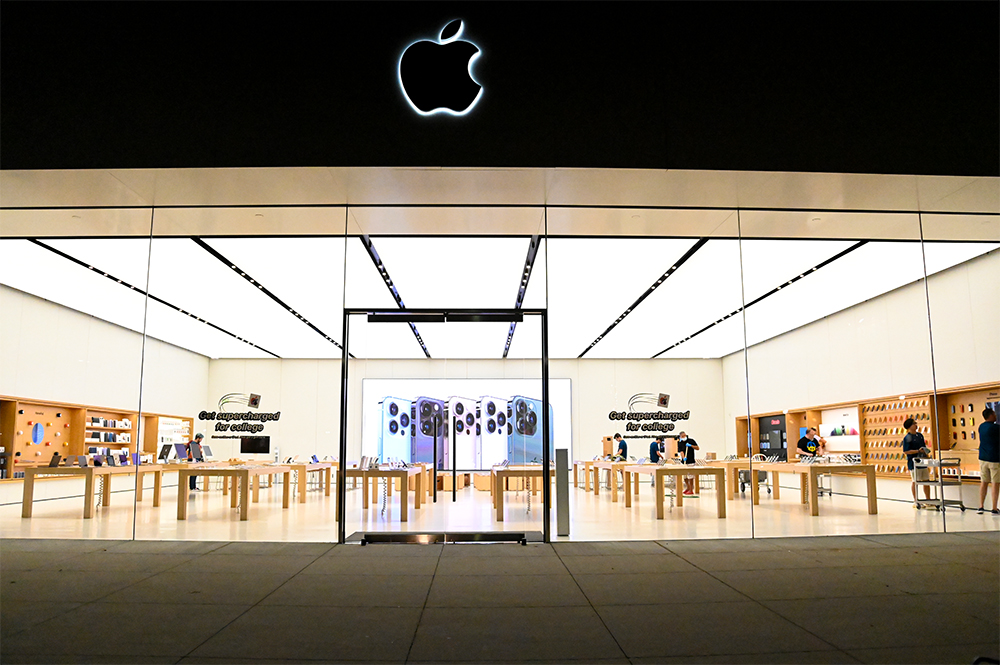 View of the entrance to the Apple Store at Derby Street Shops at night.